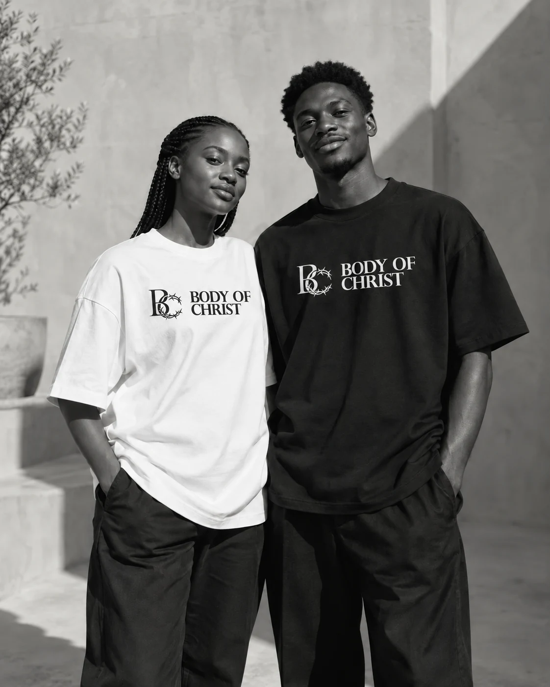 Two models wearing Body of Christ branded black and white shirts